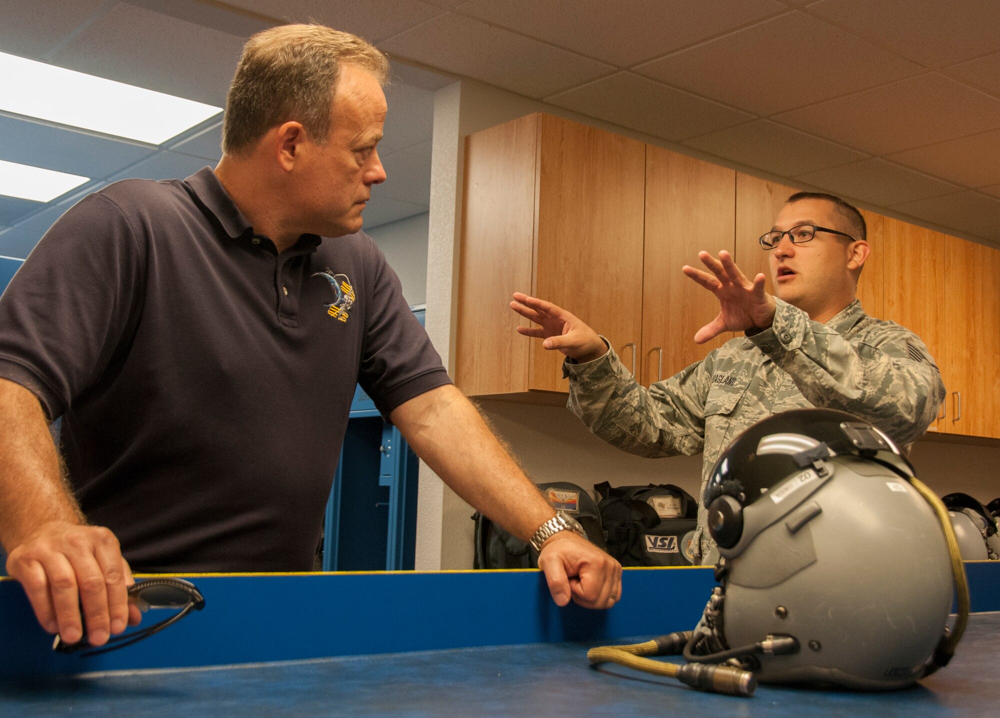 TUCSON, Ariz.—Tech Sgt. Kyle Hoagland, aircrew flight equipment technician at the 162nd Operations Group, right, discusses the changes in helmet technology with the wing’s newest honorary commander, Ron Garan. As a former fighter pilot, Garan heard pilots and support personnel describe their experiences here at the 162nd Wing and how it fits in with the total force structure. Garan is the chief pilot at World View, a Tucson-based company that plans to operate commercial near-space flight for passengers as well as scientific research via balloon. (U.S. Air National Guard photo by Capt. Logan Clark)