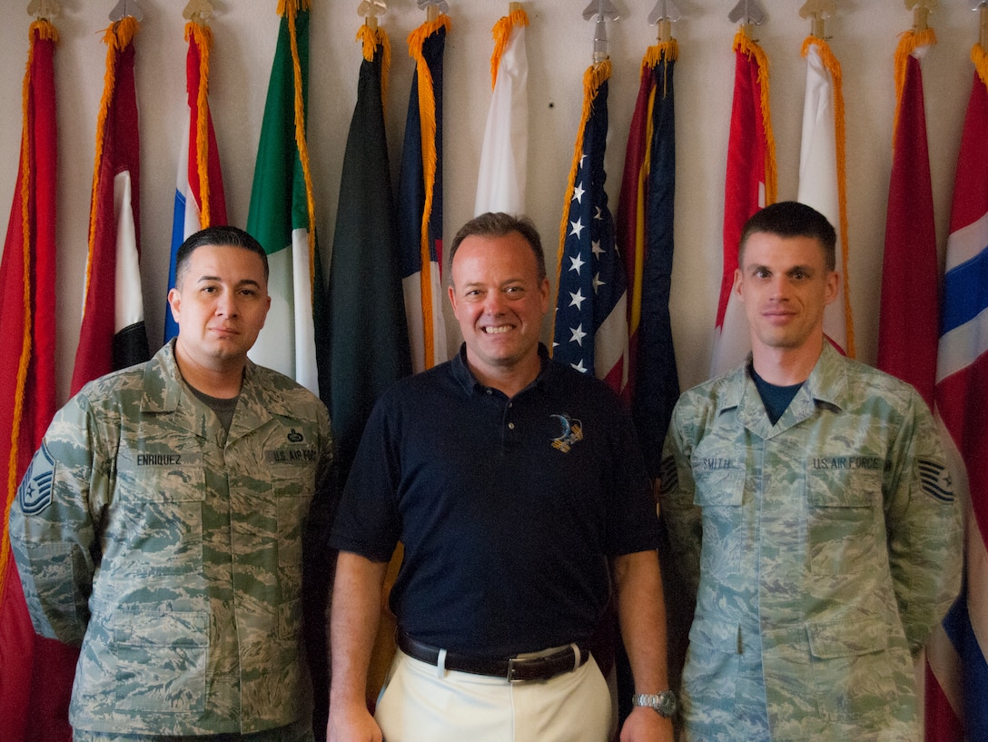 TUCSON, Ariz. – Ron Garan, the newest honorary commander at the 162nd Wing, poses for a photo with Master Sgt. Jesus Enriquez, left, and Tech. Sgt. Matthew Smith, right, in front of the partner nation flags on display at the International Military School Office here. Enriquez is the Non-Commissioned Officer in Charge of IMSO and Smith is the 162nd Operations Group unit training manager. Garan is the chief pilot at World View, a Tucson-based company that plans to operate commercial near-space flight for passengers as well as scientific research via balloon. Garan retired from active duty Air Force, and toured the base to get a feel for the Air National Guard and what a drill weekend is like.   (U.S. Air National Guard photo by Staff Sgt. Gregory Ferreira)