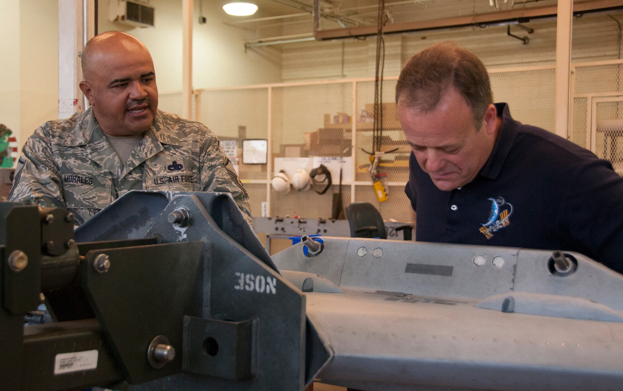 TUCSON, Ariz. – Master Sgt. Antelmo Morales, 162nd Maintenance Group armament flight aircraft systems ordnance mechanic, talks to the newest honorary commander, Ron Garan, about a wing weapons pylon that is being maintained. Garan is the chief pilot at World View, a Tucson-based company that plans to operate commercial near-space flight for passengers as well as scientific research via balloon. Garan retired from active duty Air Force, and toured the base to get a feel for the Air National Guard and talk to Airmen about drill weekend and their units’ missions.  (U.S. Air National Guard photo by Staff Sgt. Gregory Ferreira)