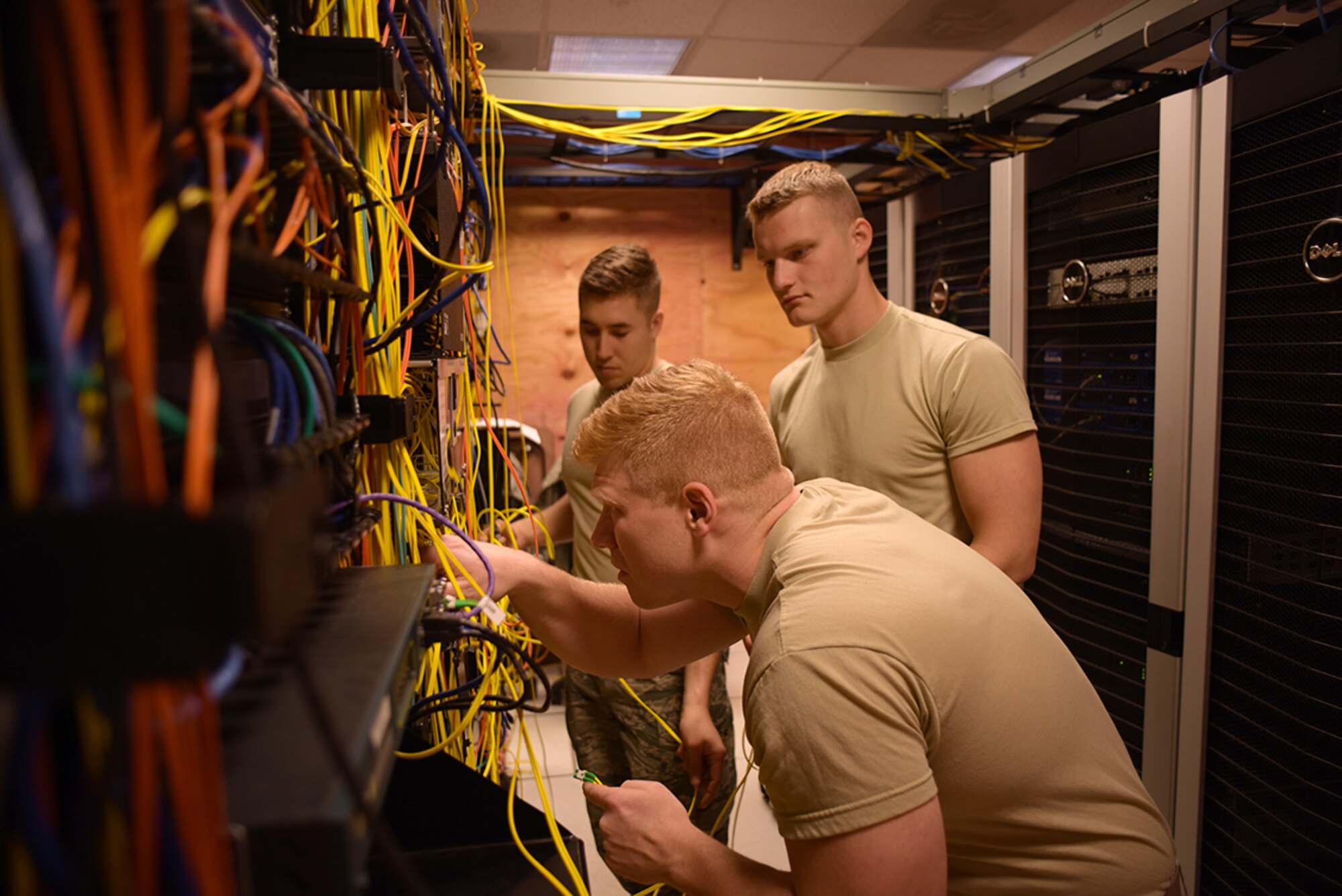 Ohio Air National Guard Airman First Class Justin Mauri, left, Senior Airman Ryan Schuett, center, and Airman First Class Joseph Blust, 178th Communication Squadron, manage fiber optic cables June 7, 2016, at Alpena Combat Readiness Training Center, Alpena Michigan.  Mauri, Schuett, and Blust managed the cables as part of a local base area network modernization project during the 178th wing annual training. (Ohio Air National Guard Photo by Master Sgt. Seth Skidmore)