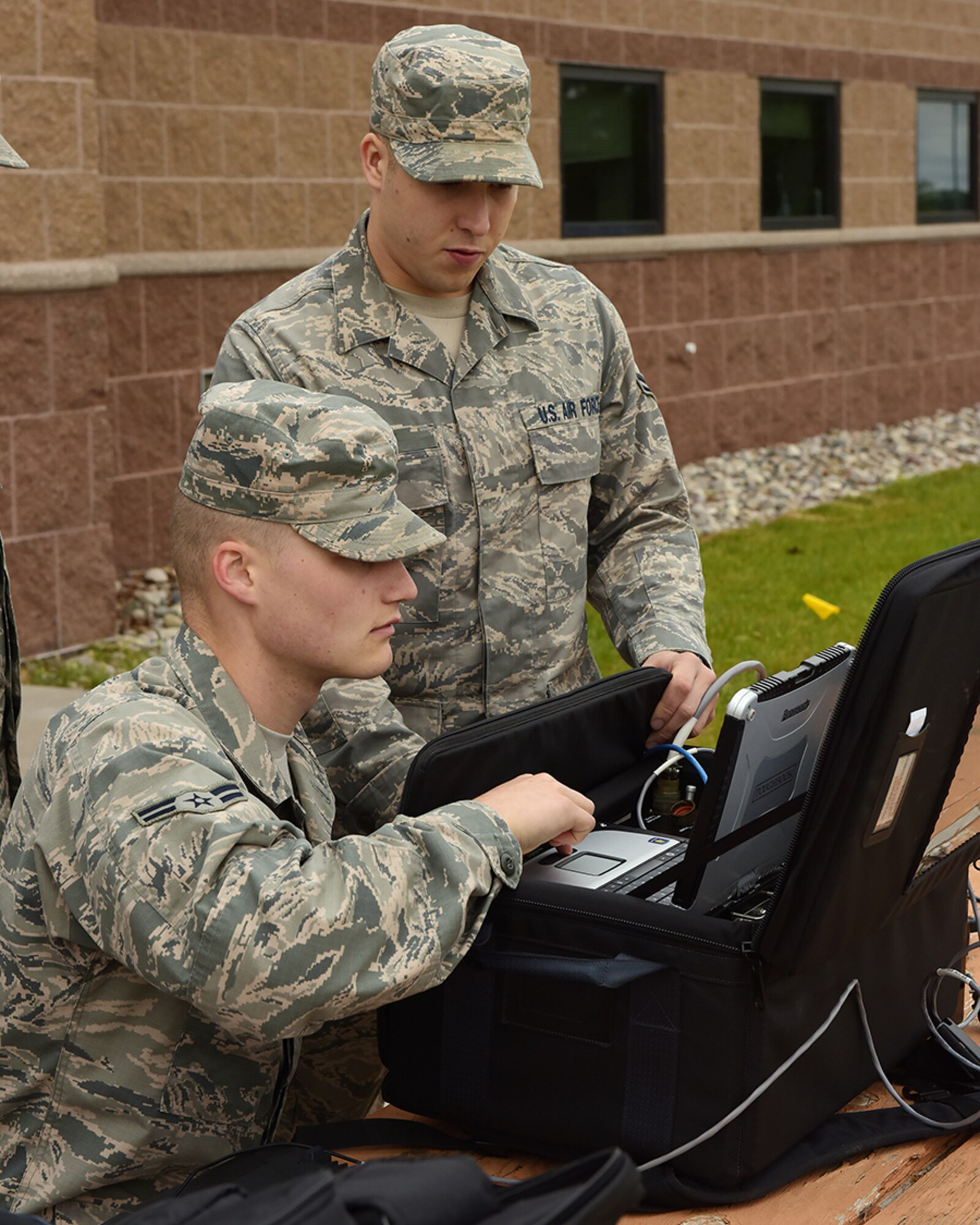 Ohio Air National Guard Airman First Class Justin Mauri and Airman First Class Joseph Blust, 178th Communication Squadron, configure a satellite receiver June 7, 2016, at Alpena Combat Readiness Training Center, Alpena Michigan.  Mauri and Blust configured the receiver as part of setting up a broadband global area network during the 178th wing annual training. (Ohio Air National Guard Photo by Master Sgt. Seth Skidmore)