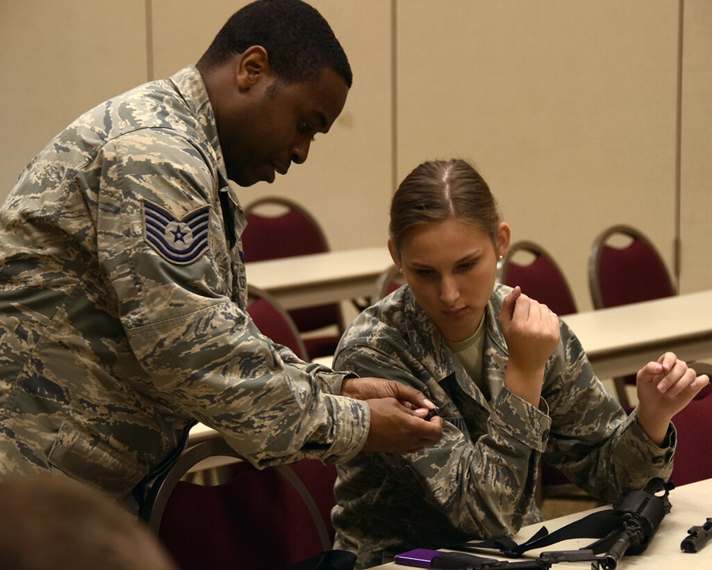 Ohio Air National Guard Tech. Sgt. John Godfrey, 178th Security Forces Squadron, left, instructs Airman First Class Allex Kautz, 178th Logistics Readiness squadron, on disassembling an M-4 carbine during weapons familiarization training June 6, 2016, at Alpena Combat Readiness Training Center, Alpena Michigan.  Godfrey instructed Kautz as part of the weapon familiarization class during the Wing training in the course of the unit’s annual summer training. (Ohio Air National Guard Photo by Master Sgt. Seth Skidmore)