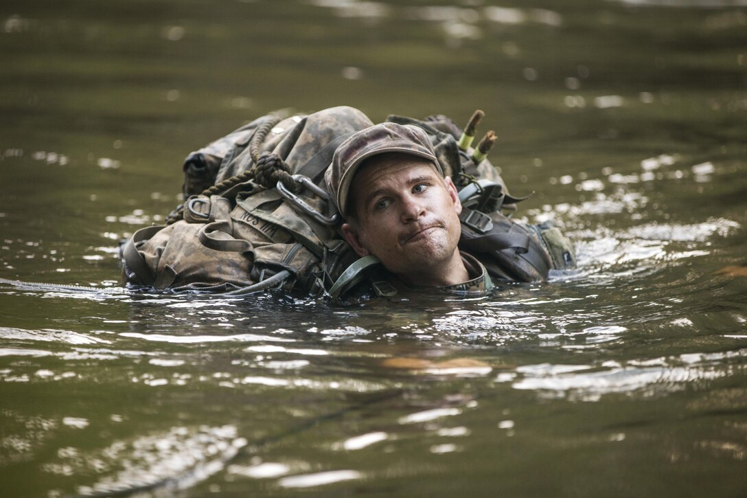 An Army Ranger student crosses a river using a submerged rope bridge during Ranger School at Camp Rudder at Eglin Air Force Base, Fla., July 7, 2016. Students must complete the school's Florida phase before earning the coveted Ranger Tab. Army photo by Sgt. Austin Berner