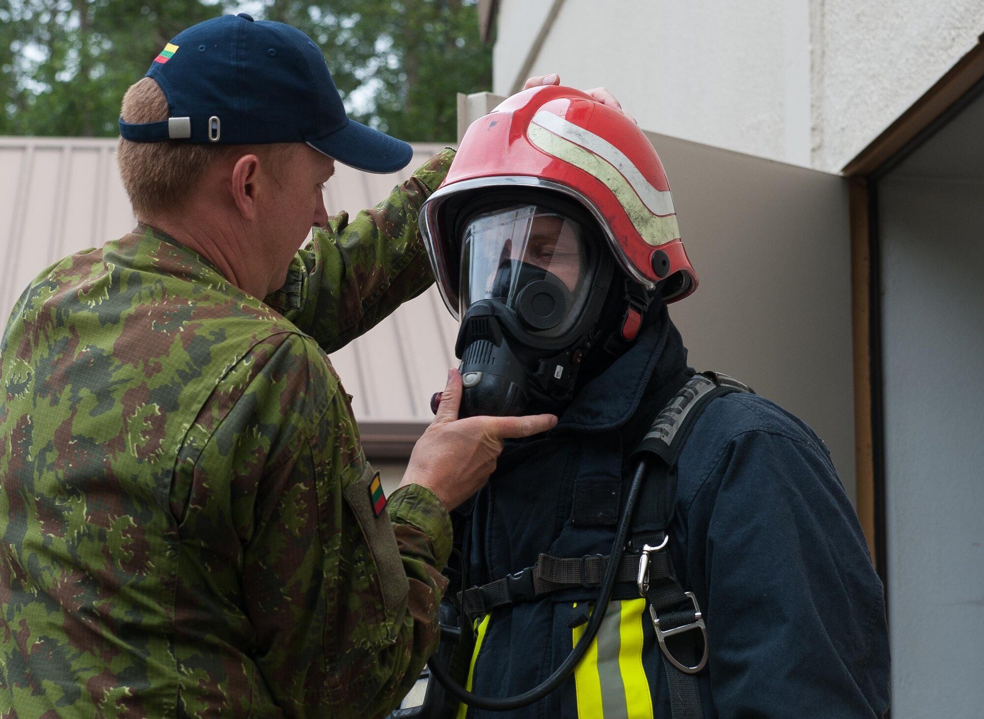 Lithuanian air force Staff Sgt. Valdas Parnarauskas, fire and rescue section commander, helps LAF Capt. Egidijus Rastikis, safety representative, equip firefighter gear before participating in a 435th Construction and Training Squadron-led training exercise July 11, 2016, at Ramstein Air Base, Germany. The 435th CTS provides sufficient training equipment and grounds for its allies to train while receiving guidance and equipment from U.S. Airmen to maintain a constant standard of mission-readiness across Europe.