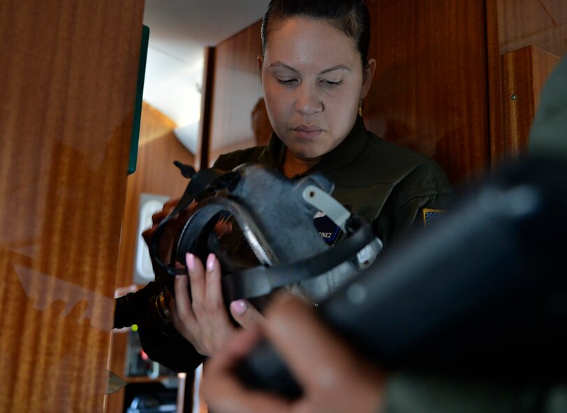 Staff Sgt. Ashleen Martinez, 76th Airlift Squadron flight attendant, reviews an oxygen mask upon departing Ramstein Air Base, Germany, July 12, 2016. Flight Attendants are trained in emergency procedures for their respective aircrafts and ensure all equipment is serviceable prior to every flight. (U.S. Air Force photo/ Senior Airman Nesha Humes)