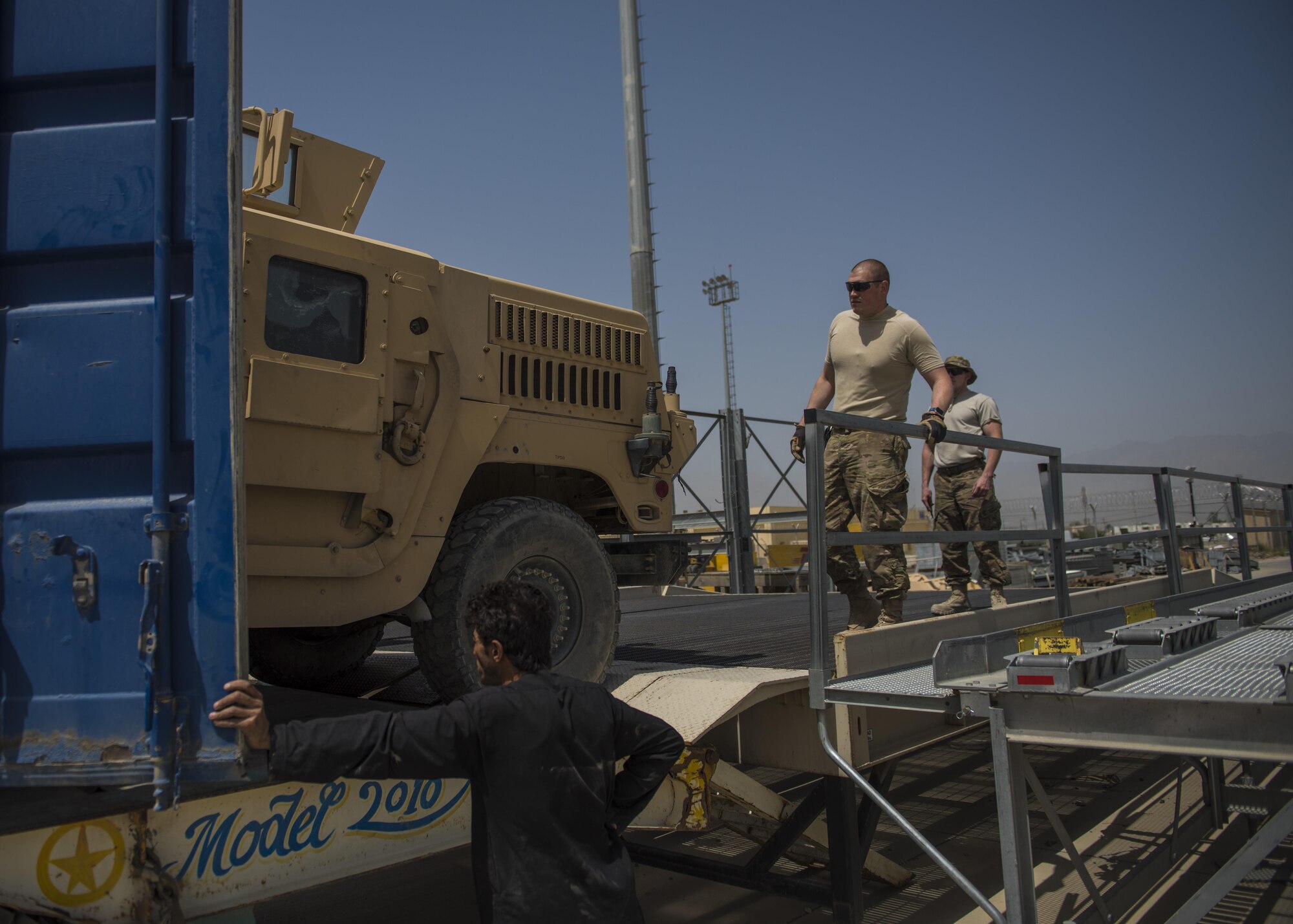 Tech Sgt. Richard Gadberry, 455th Expeditionary Logistics Readiness Squadron Central Command material recovery element, guides a high mobility multipurpose wheeled vehicle out of a container, July 14, 2016, Bagram Airfield, Afghanistan. Members of the 455th ELRS CMRE team went down to Hamid Karzai International Airport, Kabul to load up two retrograde HMMWVs to be shipped back to Bagram vehicle maintenance inspection. (U.S. Air Force photo by Senior Airman Justyn M. Freeman)