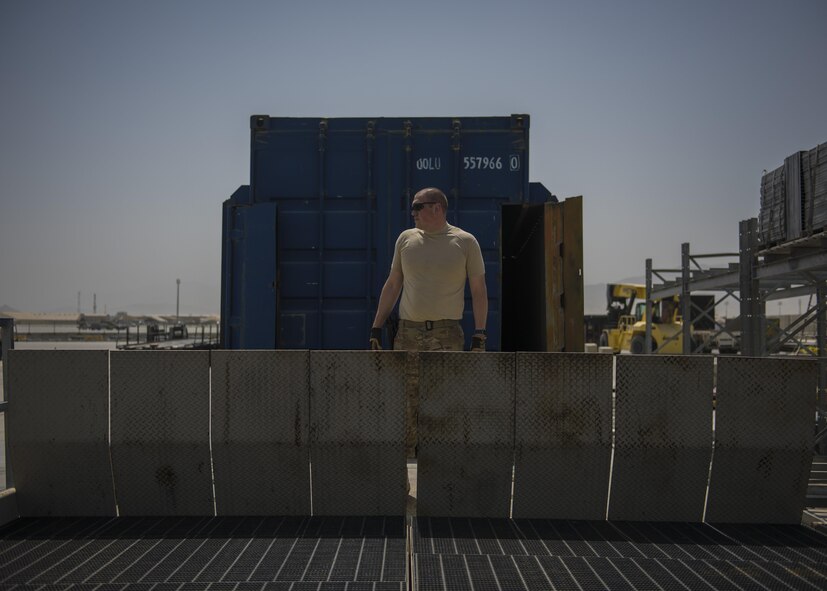 Tech Sgt. Richard Gadberry, 455th Expeditionary Logistics Readiness Squadron Central Command material recovery element, prepares to lower ramps onto a flatbed, July 14, 2016, Bagram Airfield, Afghanistan. The 455th ELRS CMRE team is tasked with conducting materiel reduction and engineer deconstruction operations in Afghanistan to procure valuable military equipment. (U.S. Air Force photo by Senior Airman Justyn M. Freeman)