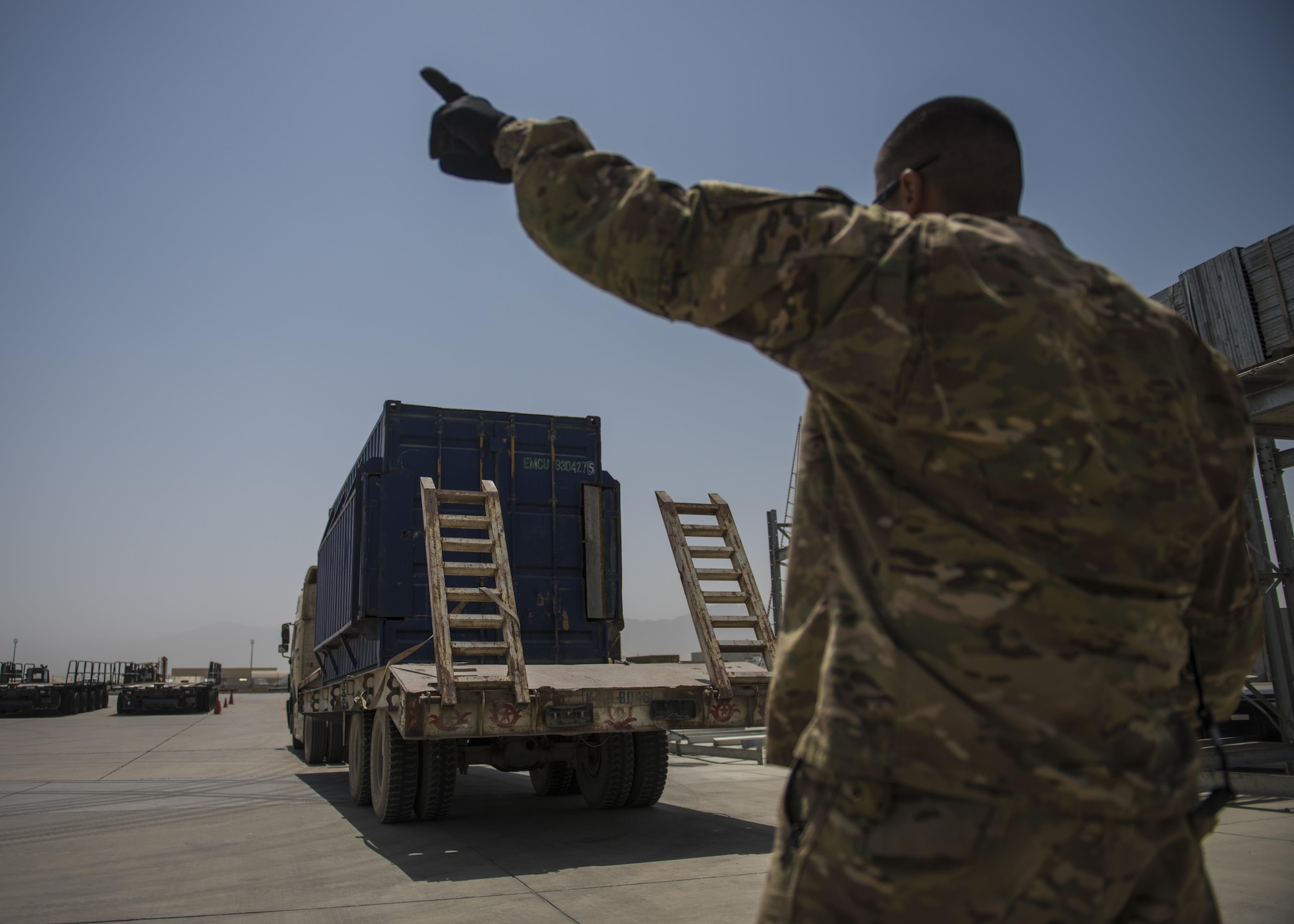 Staff Sgt. Jacob Chavez, 455th Expeditionary Logistics Readiness Squadron Central Command material recovery element, guides a delivery truck, July 14, 2016, Bagram Airfield, Afghanistan. The CMRE team accounts for and redeploys war reserve assets. (U.S. Air Force photo by Senior Airman Justyn M. Freeman)