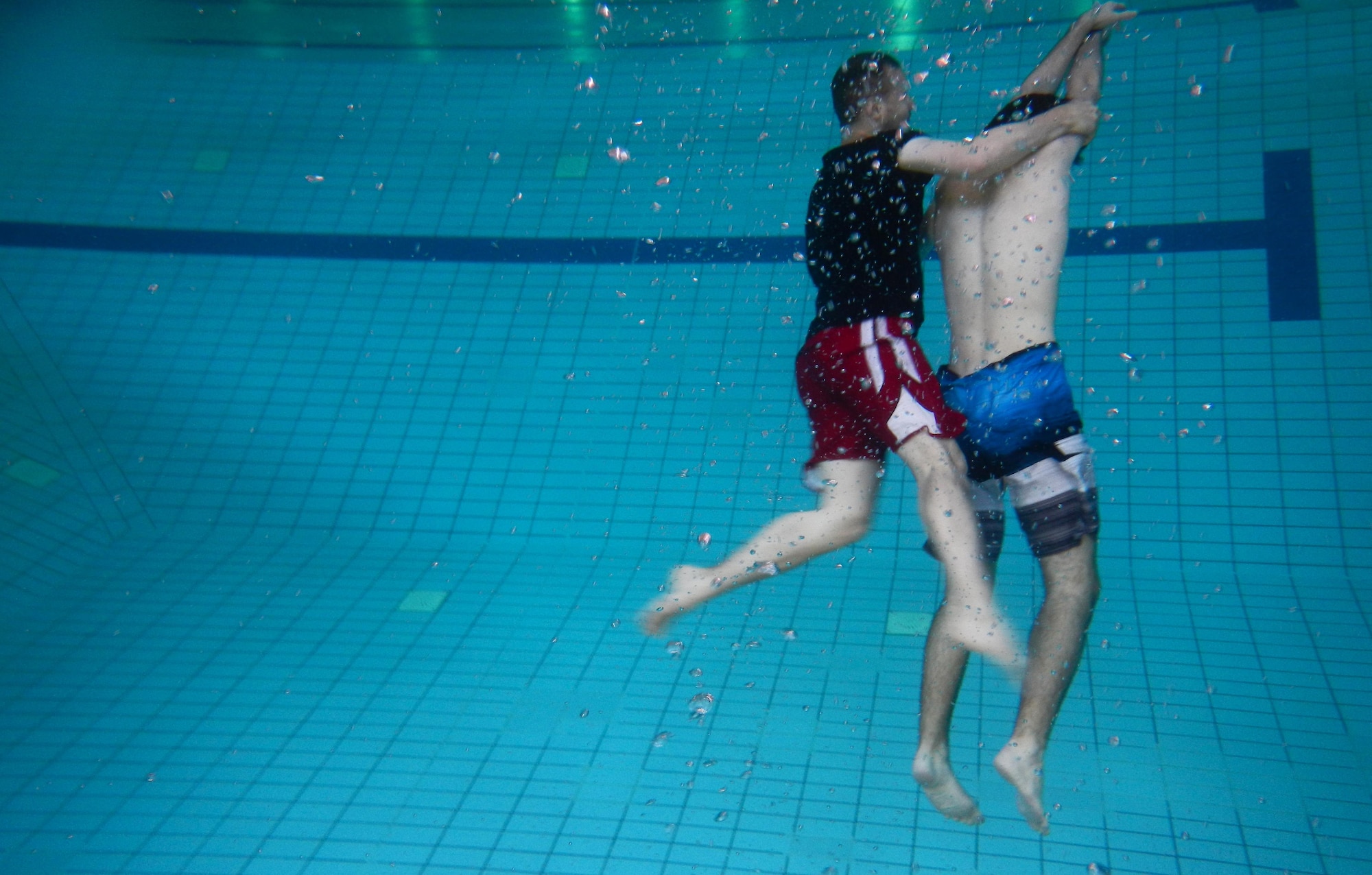 Andrew Broadwater, Ramstein Aquatic Center supervisory recreation specialist lifeguard and lifeguard course instructor, demonstrates a rescue of a victim on the bottom of the pool July 14, 2016, at Ramstein Air Base, Germany. The lifeguard course taught students how to perform rescues for victims that are conscious or unconscious, face up or face down and on the surface or on the bottom of the pool. (U.S. Air Force photo/Airman 1st Class Tryphena Mayhugh)