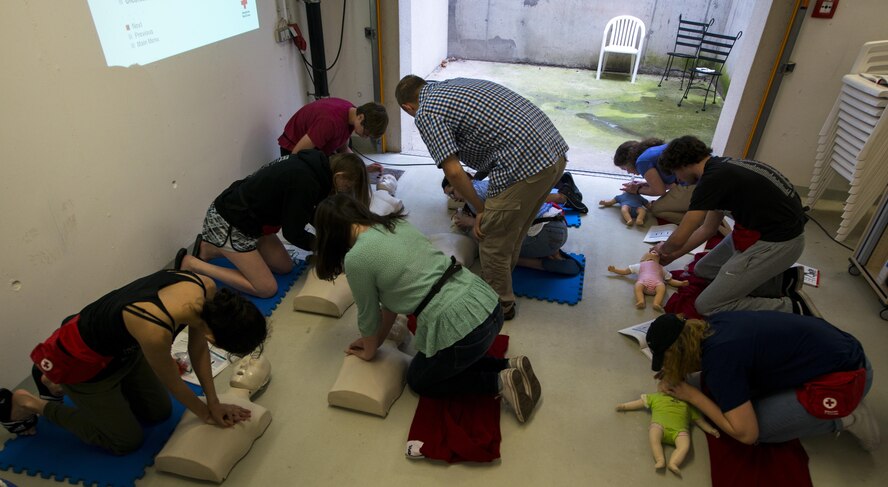 Andrew Broadwater, Ramstein Aquatic Center supervisory recreation specialist lifeguard and lifeguard course instructor, teaches students to perform chest compressions on adult and infant dummies July 13, 2016, at Ramstein Air Base, Germany. Broadwater has been a certified lifeguard for eight years and has taught the course at the aquatic center for a year and a half. (U.S. Air Force photo/Airman 1st Class Tryphena Mayhugh)