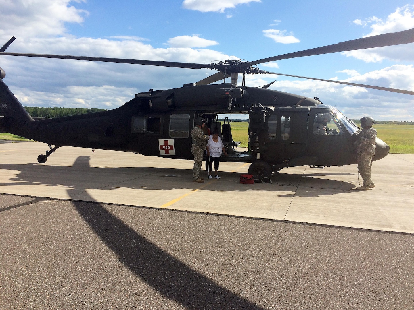Crewmembers from the Wisconsin Army National Guard’s West Bend, Wis.-based Company F, 2nd Battalion, 238th Aviation assist a dialysis patient from the Bad River Reservation in northern Wisconsin out of a UH-60 Black Hawk helicopter July 13, 2016, after conducting a medevac mission from the reservation to Ashland, Wis., for treatment. Torrential rains and severe weather that struck the area July 11 cutoff road access to the reservation and left five members of the Bad River Band of Lake Superior Chippewa unable to get to a medical facility for dialysis.