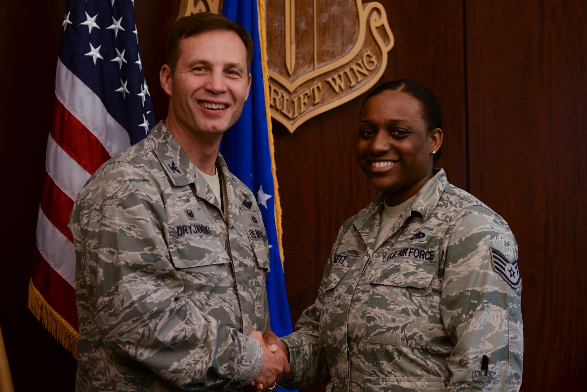 U.S. Air Force Col. James Dryjanksi, 314th Airlift Wing commander, left, congratulates U.S. Air Force Staff Sgt. Alescia Paggett, right, 314th Maintenance Group Plans and Scheduling NCO in charge, as the Combat Airlifter of the Week July 13, 2016, at Little Rock Air Force Base, Ark. Paggett created a daily, weekly and monthly maintenance schedule to ensure a 99.9 percent maintenance schedule effectiveness rate. (U.S. Air Force photo by Senior Airman Mercedes Taylor) 
