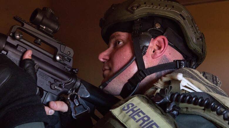 A deputy sheriff with the San Bernardino County Sheriff’s Department Special Weapons and Tactics Team sights in while clearing a building in the military operations in urban terrain facility at Range 800 aboard Marine Corps Air Ground Combat Center Twentynine Palms, Calif., July 12, 2016. The Combat Center’s Special Reaction Team hosted the cross-training to provide SBCSD with insight of the Marine Corps’ tactics capabilities. 