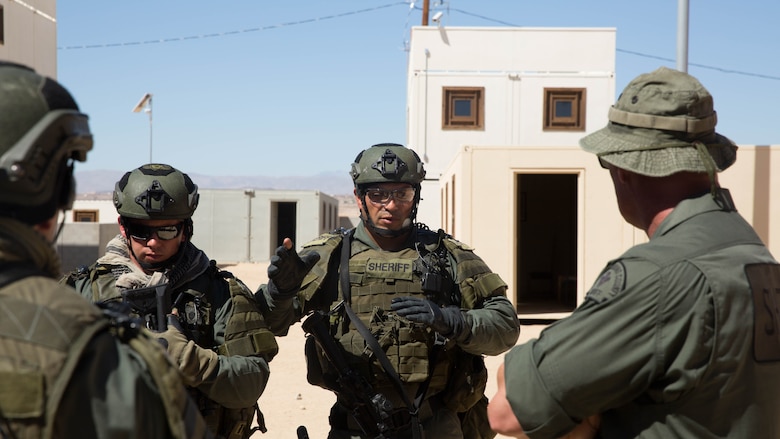 Deputy sheriffs with the San Bernardino County Sheriff’s Department Special Weapons and Tactics Team debrief after performing clearing tactics in the military operations in urban terrain facility at Range 800 at Marine Corps Air Ground Combat Center Twentynine Palms, Calif., July 12, 2016. The Combat Center’s Special Reaction Team hosted the cross-training to provide SBCSD with insight of the Marine Corps’ tactics capabilities. 