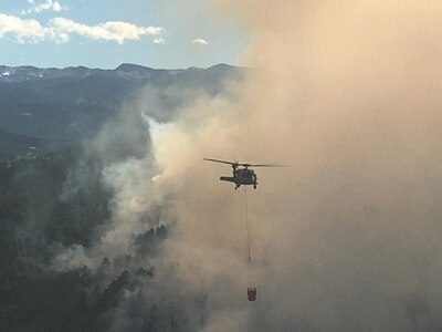 A Colorado Army National Guard UH-60 Black Hawk from Buckley Air Force Base in Aurora, Colo., drops water in support to civil authorities at the Cold Springs Fire in Nederland, Colo., July 11, 2016 