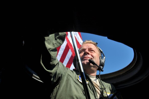 Master Sgt. Brad Pike, flight engineer with the 95th Airlift Squadron, holds the American flag out the roof escape hatch of the 440th's final C-130 aircraft as it taxied to the runway at Pope Army Airfield, June 29, 2016. A small contingent of the 440th's Airmen were on hand to watch the aircraft as it departed for its last flight before being retired. (U.S. Air Force photo by 1st Lt. Justin Clark)