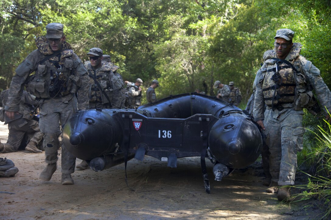 Soldiers carry an inflatable boat to a river while training at Camp Rudder at Eglin Air Force Base, Fla., July 7, 2016. Army photo by Sgt. Austin Berner