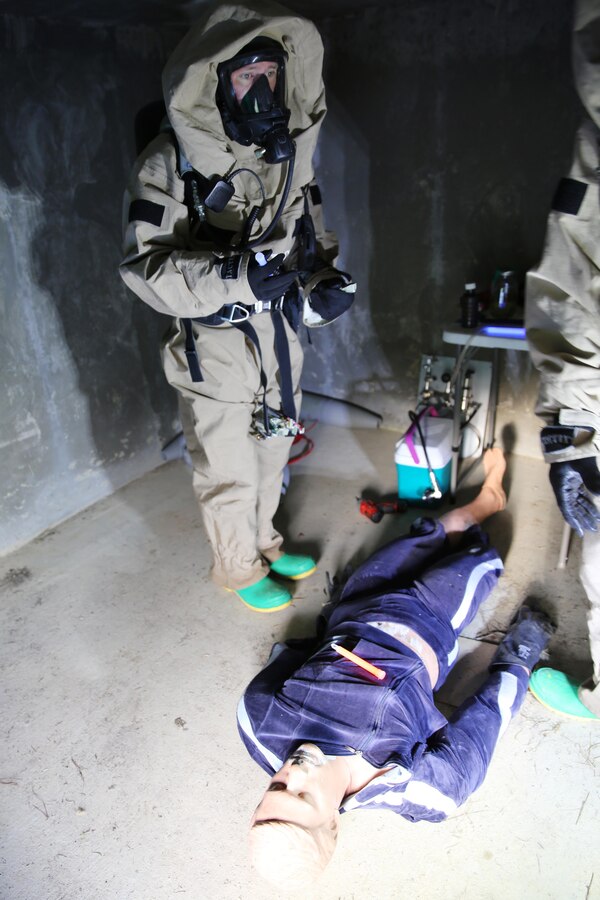 Lance Cpl. Ryan Shriver places chemical lights around a simulated incident site during a training exercise at Marine Corps Air Station Cherry Point, N.C., July 12, 2016. The training further refined the interoperability between MCAS Cherry Point Explosive Ordnance Disposal and 2nd Marine Aircraft Wing Chemical, Biological, Radiological and Nuclear Defense. Shriver is a CBRN defense specialist with Marine Wing Headquarters Squadron 2. (U.S. Marine Corps photo by Lance Cpl. Mackenzie Gibson/Released)