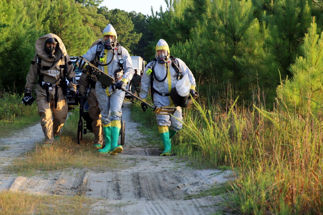 Marines with Marine Corps Air Station Cherry Point’s Explosive Ordnance Disposal and 2nd Marine Aircraft Wing’s Chemical, Biological, Radiological and Nuclear Defense walk toward a simulated incident site during a training exercise at MCAS Cherry Point, N.C., July 12, 2016. The training further refined the interoperability between EOD and CBRN. (U.S. Marine Corps photo by Lance Cpl. Mackenzie Gibson/Released)

