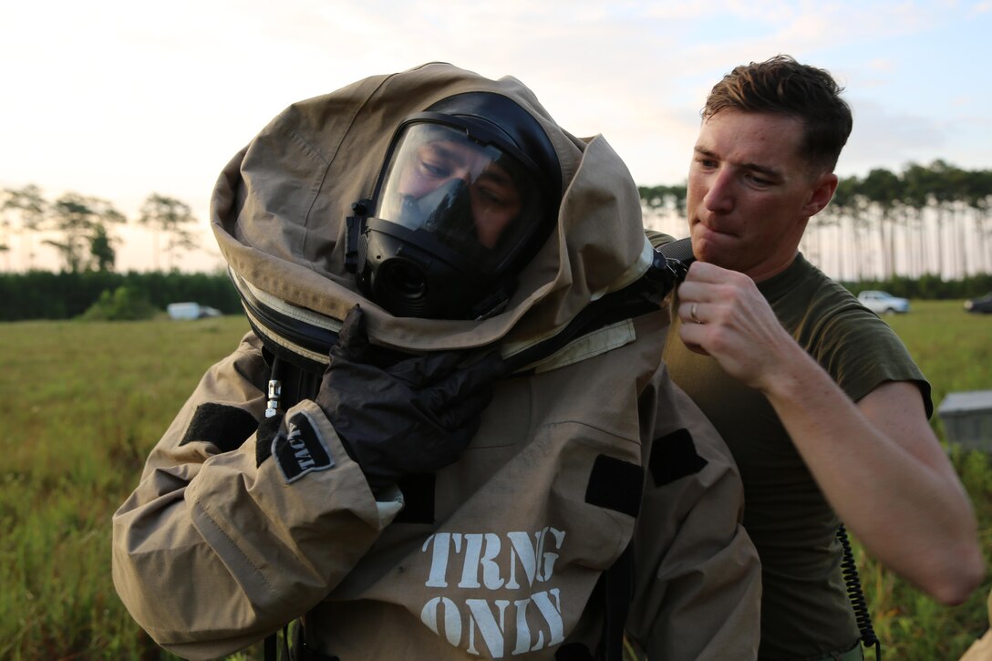 Sgt. Jarrod Roper receives help from Sgt. Christian Nelson as he dons his gear during a training exercise at Marine Corps Air Station Cherry Point, N.C., July 12, 2016. The training further refined the interoperability between MCAS Cherry Point’s Explosive Ordnance Disposal and 2nd Marine Aircraft Wing’s Chemical, Biological, Radiological and Nuclear Defense. Roper and Nelson are CBRN defense specialist with Marine Wing Headquarters Squadron 2. (U.S. Marine Corps photo by Lance Cpl. Mackenzie Gibson/Released)