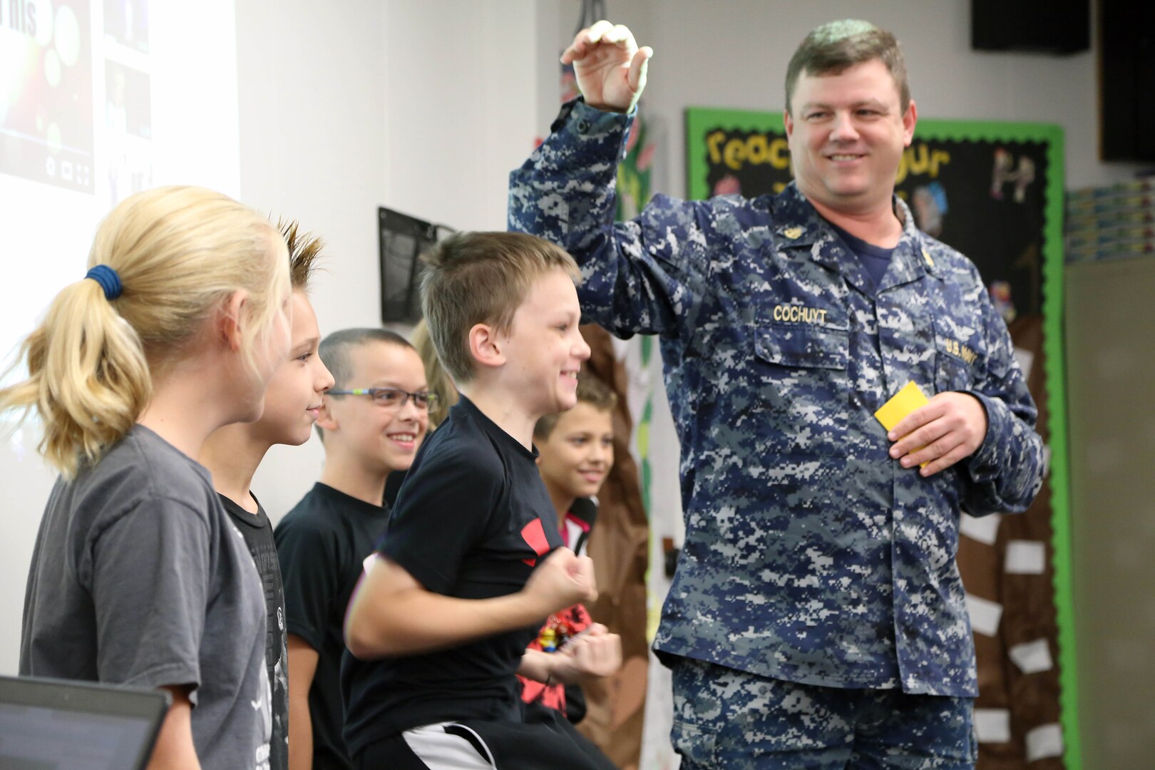 Chief Petty Officer Chad Cochuyt, Defense Contract Management Agency Boeing St. Louis technical publications/logs and records program manager, teaches local students military courtesy on how to sound "attention on deck," during a recent science, technology, engineering and mathematics outreach program event.