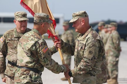 JBSA FORT SAM HOUSTON- Brig. Gen. Kenneth D. Jones passes the colors to Command Sgt. Major Paul Swanson during the Relinquishment of Command Ceremony at the MacArthur Parade Field July 9. The ceremony symbolizes the continuity of authority as the command is passed from one individual to another. 
(Photo by Spc. Eddie Serra of the 205th Press Camp Headquarters)