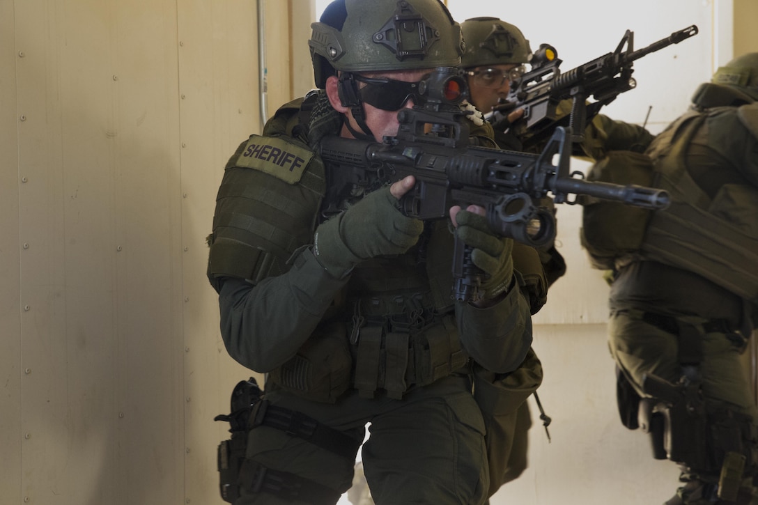A deputy sheriff with the San Bernardino County Sheriff’s Department Special Weapons and Tactics Team clears a building in the military operations in urban terrain facility at Range 800 aboard Marine Corps Air Ground Combat Center, Twentynine Palms, Calif., July 12, 2016. The Combat Center’s Special Reaction Team hosted the cross-training to provide SBCSD with insight of the Marine Corps’ tactics capabilities. (Official Marine Corps photo by Cpl. Medina Ayala-Lo/Released)