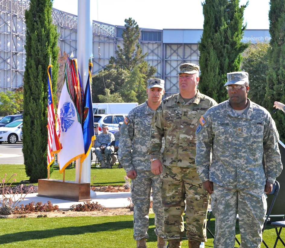 Lt. Col. Michael Stewart (left), company commander, Headquarters and Headquarters Company, 63rd Regional Support Command, Maj. Gen. Nick Tooliatos (center), commanding general, 63rd RSC and outgoing HHC commander Maj. Derrick Carter (right) pause momentarily following the ceremonial passing of the colors, during a change of command ceremony, July 13, Armed Forces Reserve Center, Mountain View, Calif.