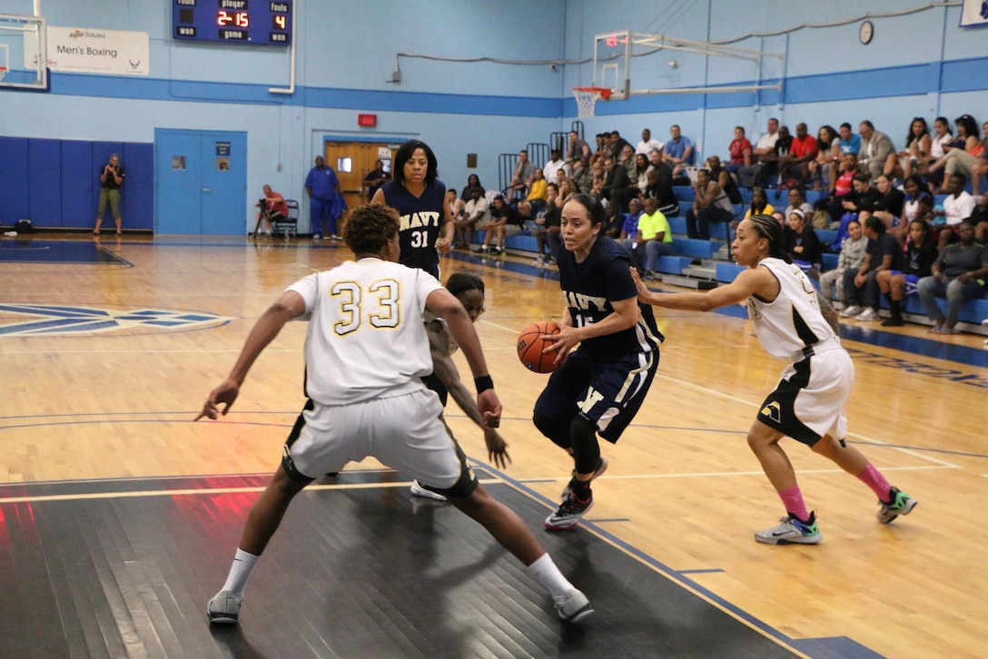 Navy Petty Officer 2nd Class Christie Ayers of the Nat'l Geo-Intel Agency, Va. drives to the lane against Army defenders during the championship game of the 2016 Armed Forces Women's Basketball Championship at Joint Base San Antonio-Lackland AFB, Texas on July 7th. Ayers scored 25-points with six-rebounds and five-assists.  Army scored at the last second to win 67-65.