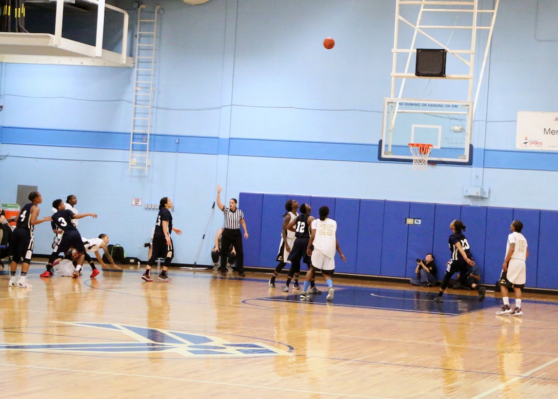 Army Spc. Vanessa Laminson of Fort Bliss, Texas (far left, white jersey on the floore) hits the three-point basket as time expires with the ball in the air during the championship game of the 2016 Armed Forces Women's Basketball Championship at Joint Base San Antonio-Lackland AFB, Texas on July 7th. Laminson's basket gave Army the gold with a 67-65 over Navy.