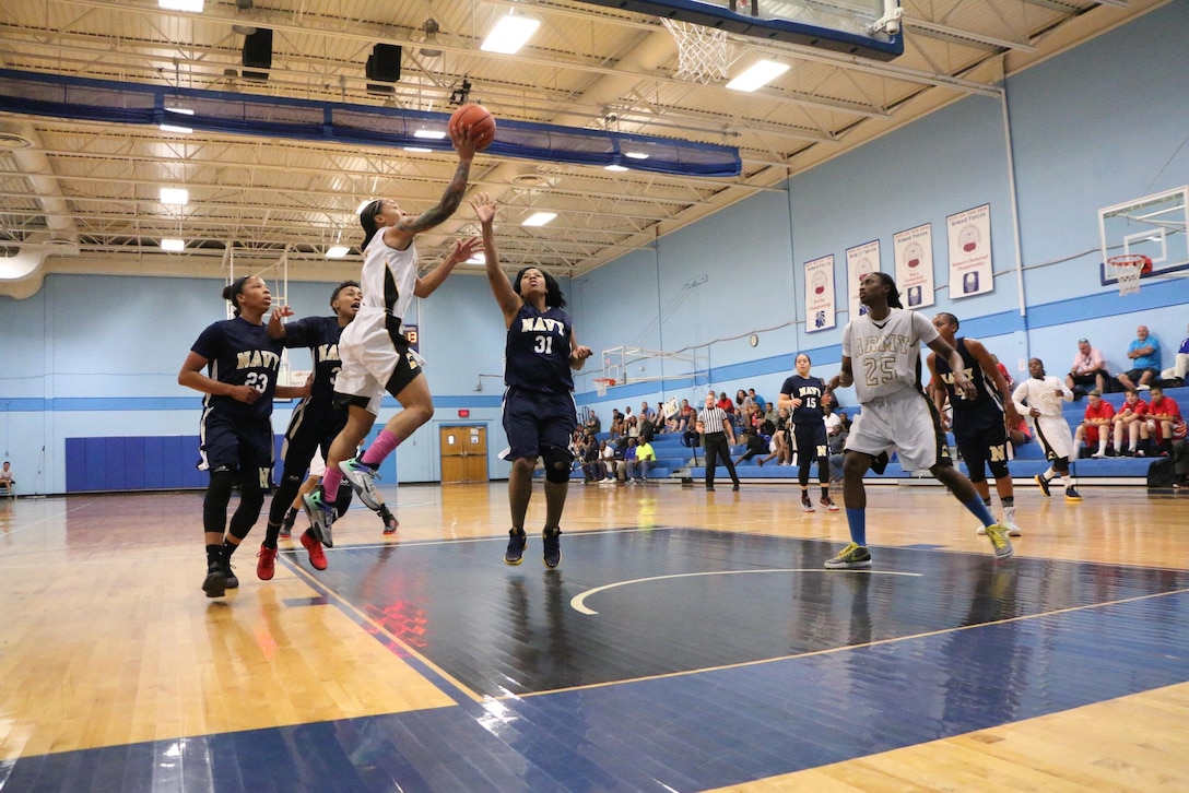 Army Spc. Vanessa Laminson of Fort Bliss, Texas drives to the lane against Navy defenders during the championship game of the 2016 Armed Forces Women's Basketball Championship at Joint Base San Antonio-Lackland AFB, Texas on July 7th. Laminson would score the winning basket as time expired immediately after the ball left her hands. Army won 67-65