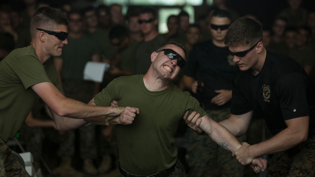 Marines with 3rd Battalion, 2nd Marine Regiment tenses up when struck with the tasers barbs during a non-lethal weapons course at Marine Corps Base Camp Lejeune, N.C., July 15, 2016. Throughout the course they learned about various take-down techniques utilizing a police baton, riot control formations and tactics as well as the function and result of using a taser. 