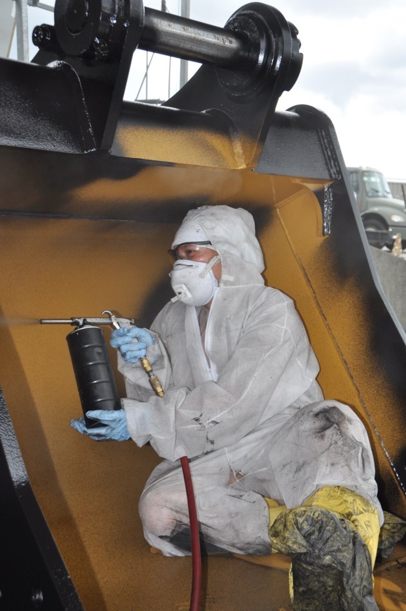 Staff Sgt. Amber Melgoza-Kulesza, 944th Logistics Readiness Squadron Fuels section, endures extremely high temperatures and humidity, while spraying corrosive preventive compound on Airfield Damage Repair construction equipment at Kadena Air Base, Japan, June 30, 2016. The ADR program has 250 assets on reserve and ready for any airfield disaster. This spray process saves 3.5 million dollars every five years in vehicle maintenance repair cost. Citizen Airmen with Luke’s 944th LRS travelled to Kadena as part of their annual tour to provide extra manning for their active-duty counterparts. 