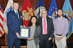 DLA Director Air Force Lt. Gen. Andy Busch (far left) presents an award to Air Force Lt. Col. Teresa Rivers for supporting her husband, Randy Taft (second from right) in his career  as son Cody Taft (far right) looks on.