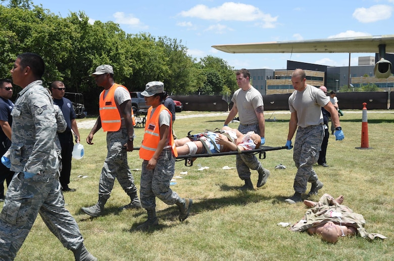 Disaster response team members from the 59th Medical Wing transport a simulated patient to an ambulance during a July 13, 2016 exercise at Camp Bramble on Joint Base San Antonio-Lackland, Texas. More than 50 Airmen participated in the exercise, which simulated an aircraft crash designed to test the team’s ability to respond and treat patients in the event of a real-world incident. (U.S. Air Force photo/Staff Sgt. Jerilyn Quintanilla)