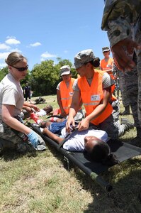 Members of the 59th Medical Wing disaster response team secure a patient to a litter prior to transport during a July 13, 2016 exercise at Camp Bramble on Joint Base San Antonio-Lackland, Texas. More than 50 Airmen participated in the exercise, which simulated an aircraft crash designed to test the team’s ability to respond and treat patients in the event of a real-world incident. (U.S. Air Force photo/Staff Sgt. Jerilyn Quintanilla)