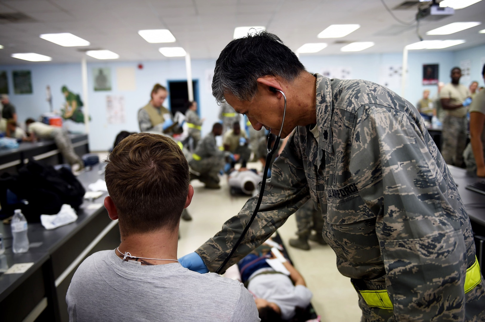 Lt. Col. Eddie Uy, a 59th Medical Wing staff pediatrician, examines a patient with simulated injuries during the July 13, 2016 disaster response exercise at Camp Bramble on Joint Base San Antonio-Lackland, Texas. The exercise, which simulated an aircraft crash, was designed to test the medics’ response skills in the event of a similar real-world incident. (U.S. Air Force photo/Staff Sgt. Jerilyn Quintanilla)