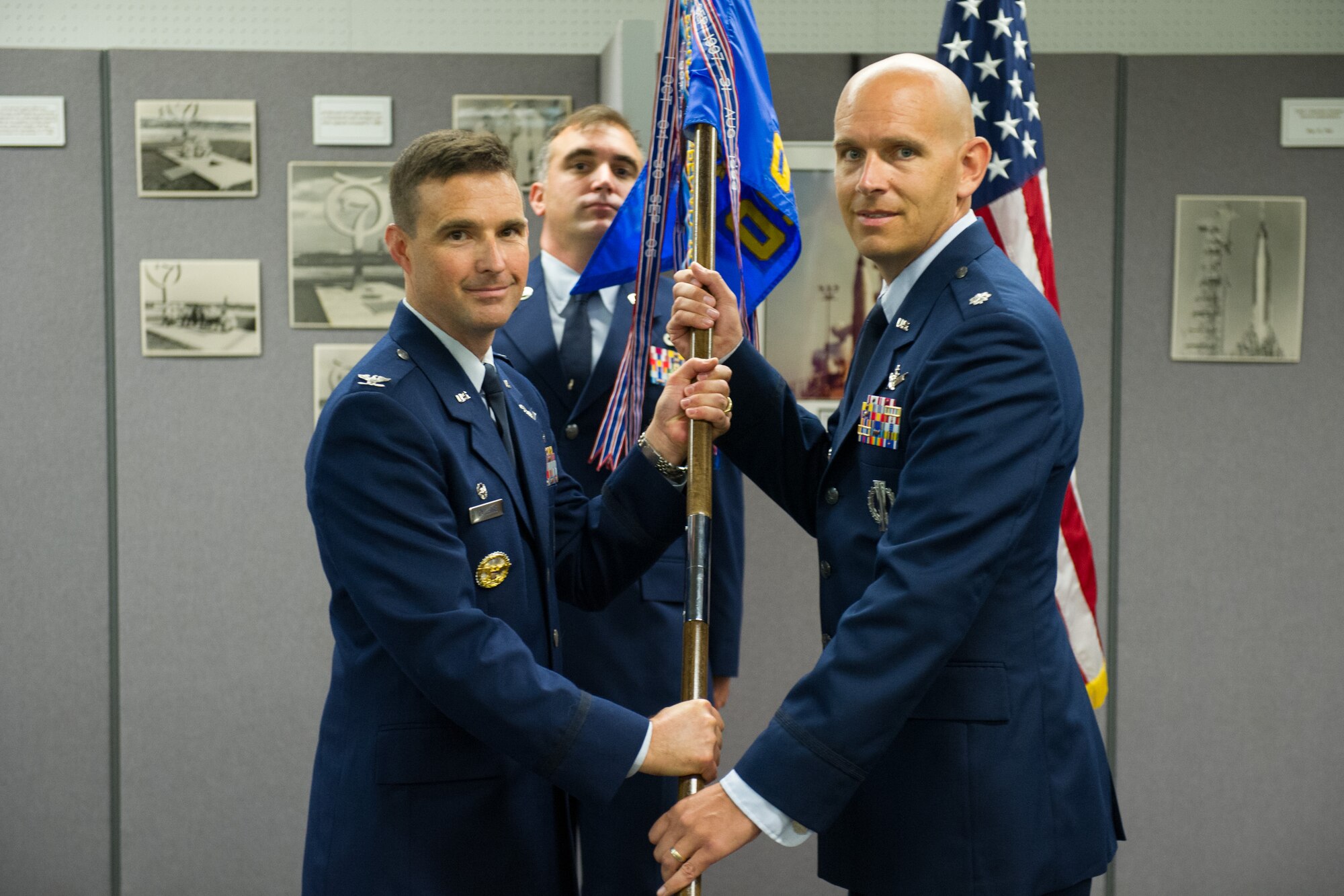 Col. Burton Catledge, 45th Operations Group commander, presents Lt. Col. Robert Shrader, 45th Operations Support Squadron commander, with a guidon during a change of command ceremony July 15, 2016, at Cape Canaveral Air Force Station, Fla. Changes of command are a military tradition representing the transfer of responsibilities from the presiding official to the upcoming official. (U.S. Air Force photo/Benjamin Thacker)