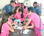 Navy recruiters, Machinist’s Mate 2nd Class Deron Davis of Navy Recruiting Station (NRS) Hollywood Park and Aviation Boatswain’s Mate 2nd Class Benjamin Brown of NRS De Zavala observe middle school girls assemble an underwater remotely operated vehicle (ROV) during a SeaPerch Competition held at the Ann Barshop Natatorium on the campus of the University of the Incarnate Word as a part of the miniGEMS (Girls in Engineering, Math and Sciences) program.  SeaPerch is an innovative underwater robotics program that equips teachers and students with the resources they need to build an underwater ROV in an in-school or out-of-school setting.  Davis, a native of Nacogdoches, Texas, is a graduate of Chireno High School in Chireno, Texas, and Brown, a native of Albany, Ga., graduated from Westover High School.  (U.S. Navy Photo by Burrell Parmer, Navy Recruiting District San Antonio Public Affairs/Released)