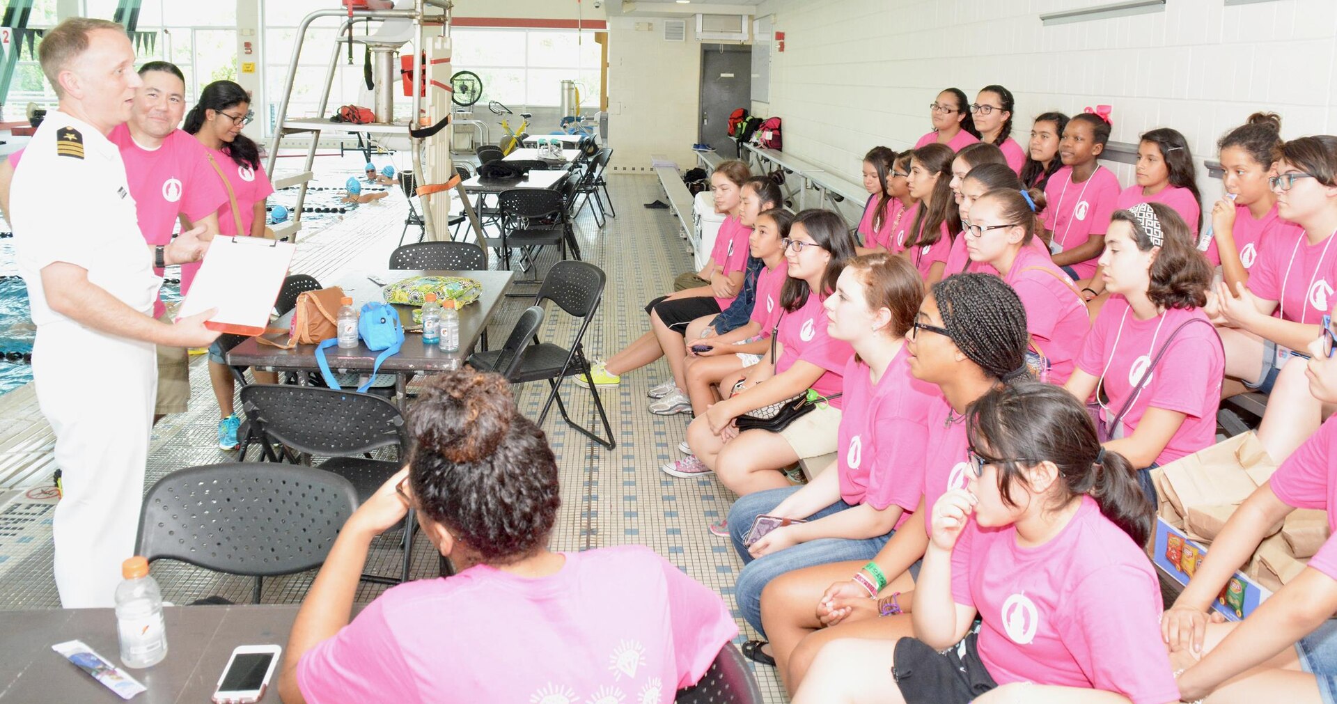 Cmdr. Jeffrey Reynolds, executive officer, Navy Recruiting District San Antonio, speaks with middle school girls after the completion of a SeaPerch Competition held at the Ann Barshop Natatorium on the campus of the University of the Incarnate Word as a part of the miniGEMS (Girls in Engineering, Math and Sciences) program.  SeaPerch is an innovative underwater robotics program that equips teachers and students with the resources they need to build an underwater ROV in an in-school or out-of-school setting. (U.S. Navy Photo by Burrell Parmer, Navy Recruiting District San Antonio Public Affairs/Released)
