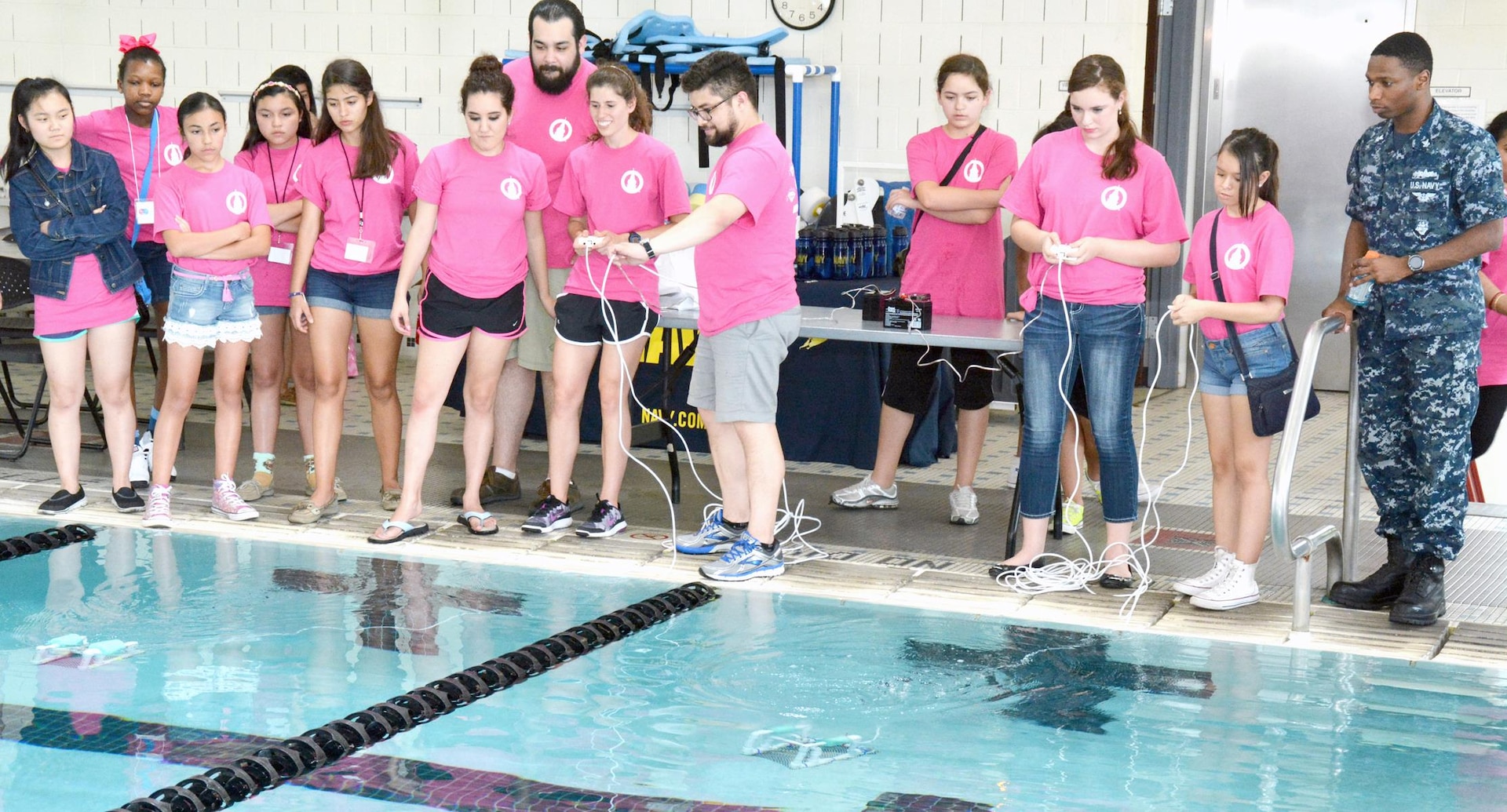 Machinist’s Mate 2nd Class Deron Davis, a recruiter with Navy Recruiting Station Hollywood Park judges a speed race of underwater remotely operated vehicles (ROV) during a SeaPerch Competition held at the Ann Barshop Natatorium on the campus of the University of the Incarnate Word as a part of the miniGEMS (Girls in Engineering, Math and Sciences) program.  SeaPerch is an innovative underwater robotics program that equips teachers and students with the resources they need to build an underwater ROV in an in-school or out-of-school setting.  Davis, a native of Nacogdoches, Texas, is a graduate of Chireno High School in Chireno, Texas. (U.S. Navy Photo by Burrell Parmer, Navy Recruiting District San Antonio Public Affairs/Released)