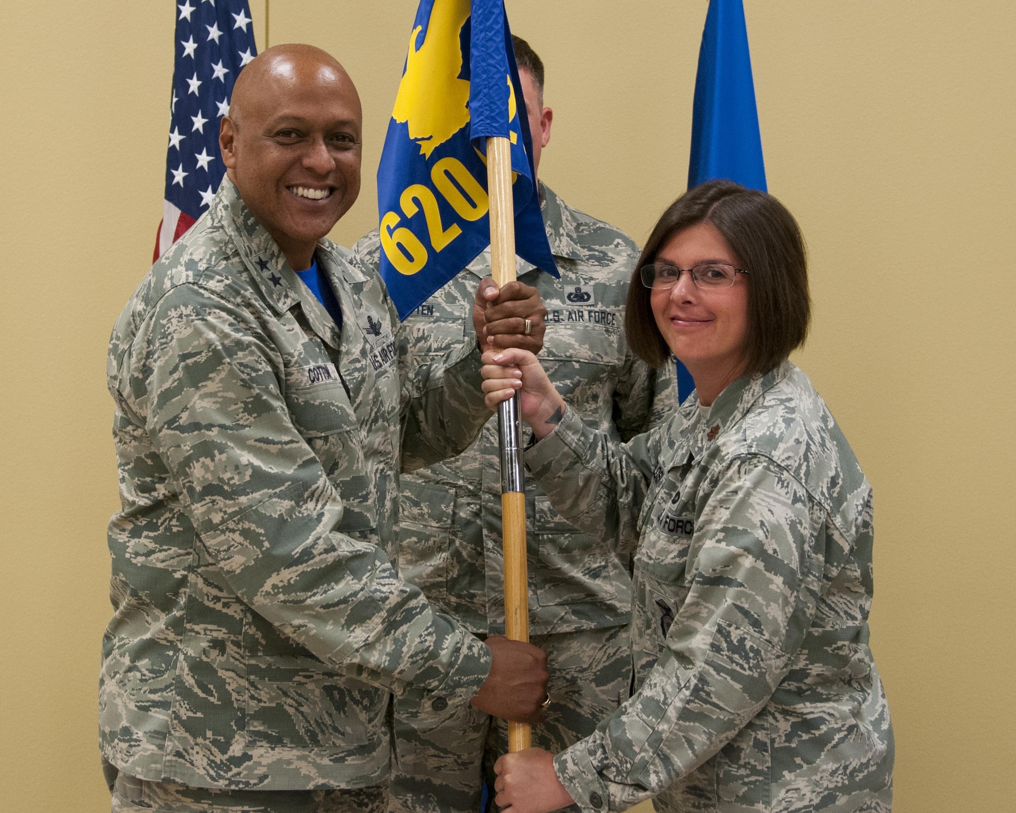 Maj. Gen. Anthony Cotton, 20th Air Force and Task Force 214 commander, passes the 620th Ground Combat Training Squadron guidon to the squadron’s new commander, Maj. Kristen Cangelosi, during a change-of-command ceremony July 15, 2016, at Camp Guernsey, Wyo. The ceremony signified the transition of command from Maj. Mike Piernick to Maj. Kristen Cangelosi. (U.S. Air Force photo by Senior Airman Jason Wiese)
