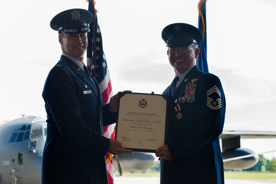 U.S. Air Force Col. Thomas Dorl, 347th Rescue Group commander, presents a retirement certificate to Chief Master Sgt. Maxie Gainey, 347th RQG chief enlisted manager, July 15, 2016, at Moody Air Force Base, Ga. Gainey has served as the group chief enlisted manager since March 2014 and has been at Moody AFB since February 2013. (U.S. Air Force photo by Tech. Sgt. Zachary Wolf)
