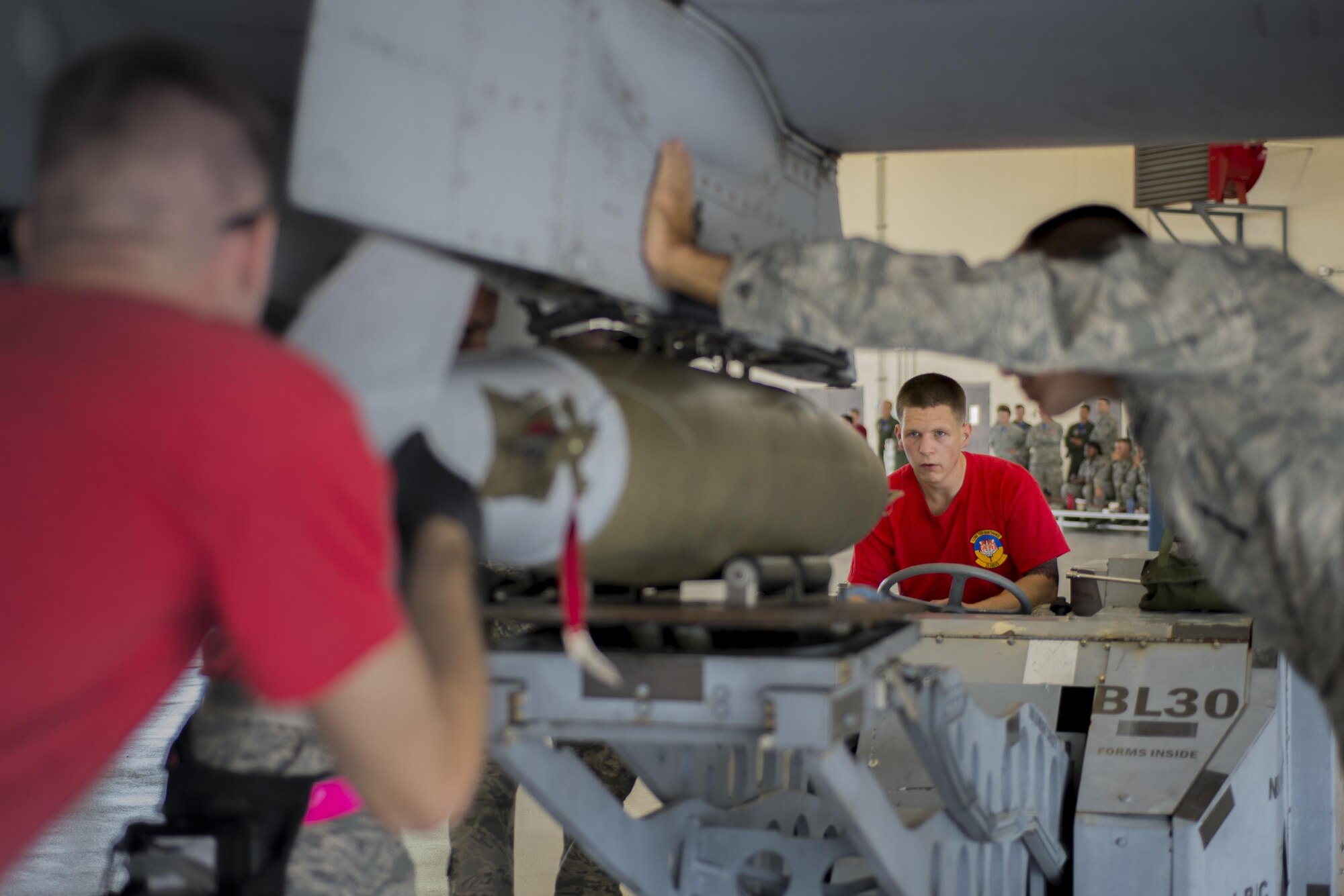 U.S. Air Force Senior Airman Logan McFarland, 75th Aircraft Maintenance Unit load crew member, guides a low drag training bomb to an A-10C Thunderbolt II during a load competition, July 15, 2016, at Moody Air Force Base, Ga. During the competition, load crews compete by safely and efficiently loading one AIM-9 training missile, one GBU-12 joint direct attack training munition and one MK-82 Low Drag training bomb. (U.S. Air Force Photo by Airman Daniel Snider)