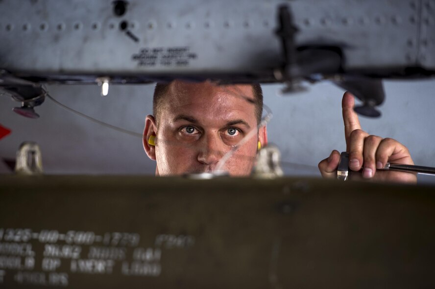 U.S. Air Force Staff Sgt. Dayton Gravlee, 74th Aircraft Maintenance Unit load crew member, directs the movement of a munition towards an A-10C Thunderbolt II during a weapons load competition, July 15, 2016, at Moody Air Force base, Ga. Each crew starts with 1,500 points divided among four categories: 800 for loading, 300 for a written test, 300 for a tool box inspection and 100 for a dress and appearance inspection. Points are deducted for infractions within a respective category. (U.S. Air Force photo by Senior Airman Ryan Callaghan)