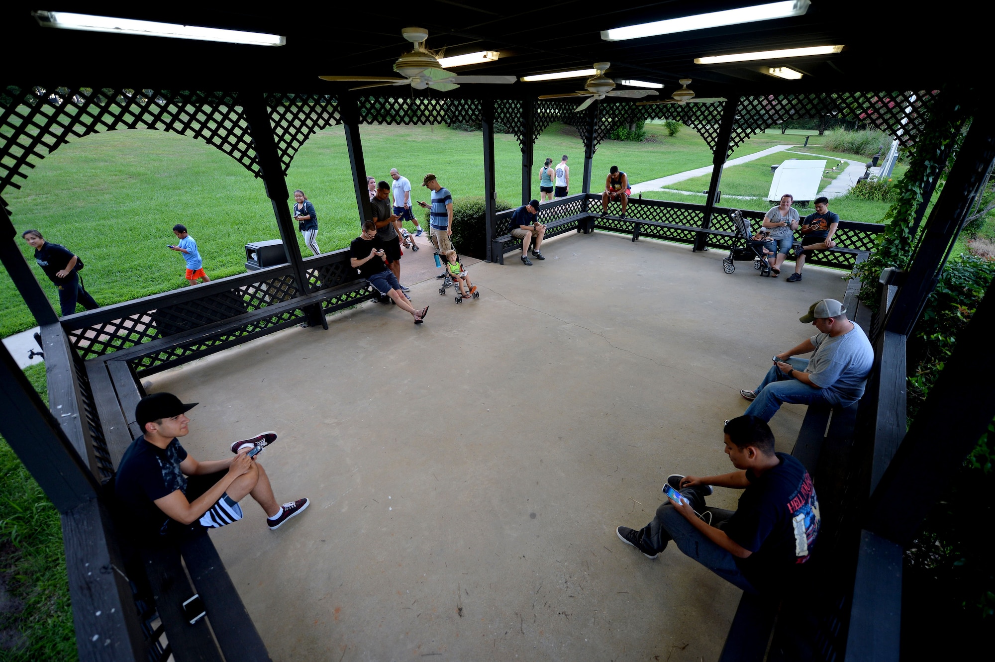 Members of Team Shaw gather in a gazebo at Memorial Lake to play the new game Pokémon Go with other players at Shaw Air Force Base, S.C., July 12, 2016. Since the game was released July 6, members of Team Shaw have gathered each night at Memorial Lake to play the game with others wanting to relive a piece of their childhood, foster new relationships and inadvertently strengthening the Team Shaw community. (U.S. Air Force photo by Senior Airman Michael Cossaboom)