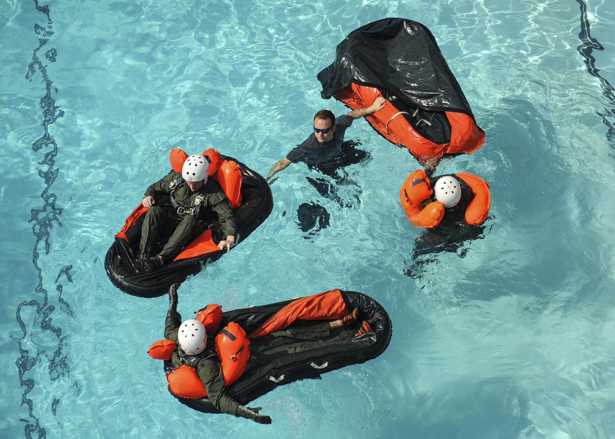 U.S. Air Force Tech. Sgt. Jerrod Mink, 19th Operations Support Squadron survival, evasion, resistance and escape specialist, center, instructs C-130J aircrew members how to properly use inflatable single-person life rafts June 24, 2016, at Little Rock Air Force Base, Ark. Along with floatation devices, the C-130J is equipped with helmets, oxygen masks and survival kits in case of emergencies. (U.S. Air Force photo by Senior Airman Harry Brexel)