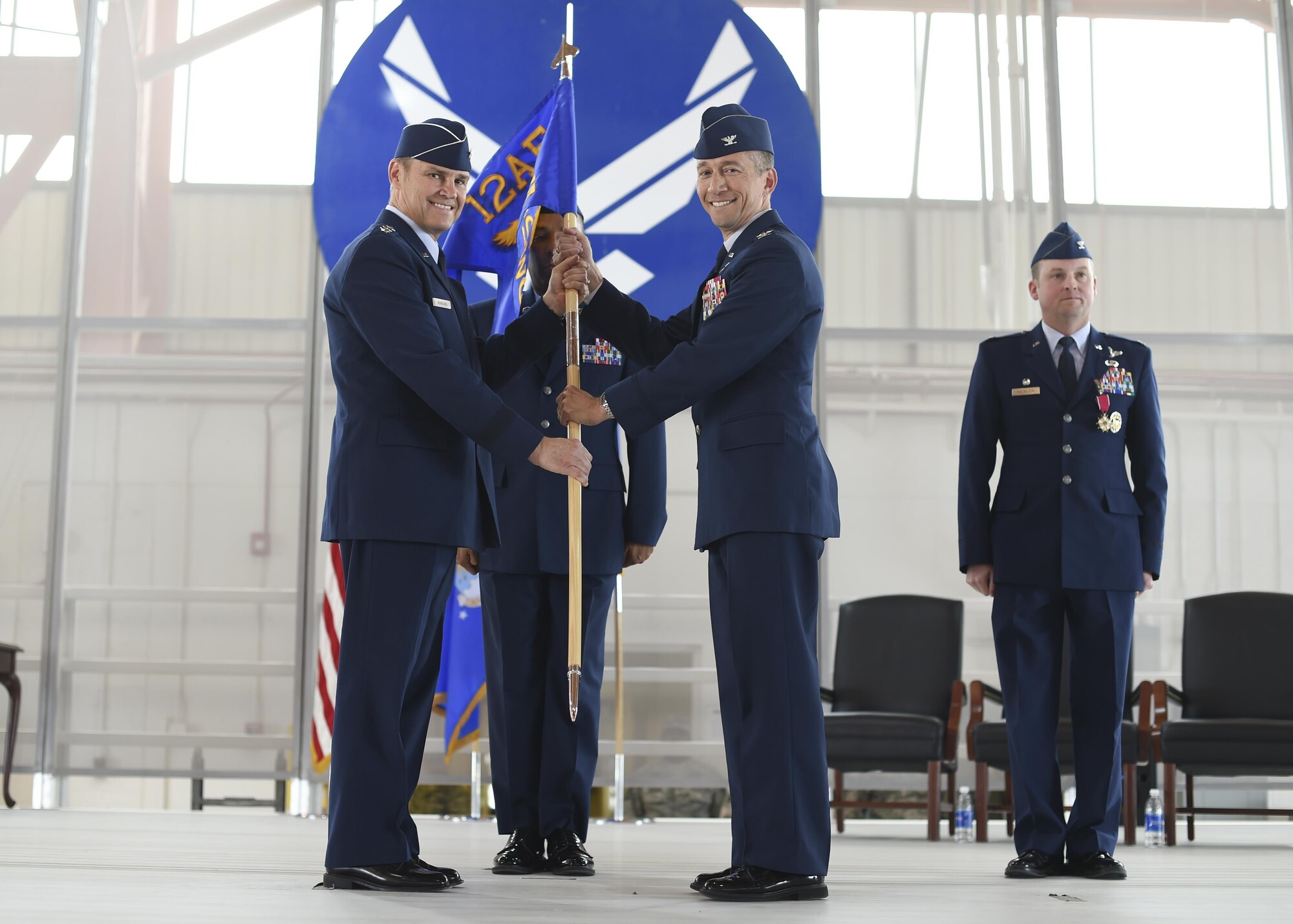 Col. Houston Cantwell, the 49th Wing commander revives the 49th Wing gidon from Lt. Gen. Mark Nowland the 12th Air Force commander during a change-of-command ceremony July 15 at Hangar 500 at Holloman Air Force Base N.M. Col. Houston Cantwell assumed command of the 49th Wing and Holloman Air Force Base from the previous commander, Col. Robert Kiebler. As commander of the 49th Wing, Cantwell will lead Holloman’s mission to provide combat-ready Airmen, train MQ-1 Predator and MQ-9 Reaper pilots and sensor operators, and hosts the 54th Fighter Group's F-16 Fighting Falcon pilot training mission, the 96th Test Group's high-speed test track mission and the German Air Force Flying Training Center. (U.S. Air Force Photo by: Staff Sgt. Stacy Moless)