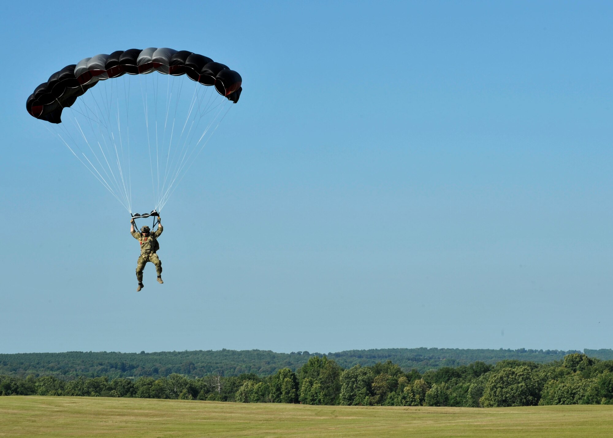U.S. Air Force Tech. Sgt. Jerrod Mink, 19th Operations Support Squadron survival, evasion, resistance and escape specialist, prepares to land June 29, 2016, at Blackjack Drop Zone in Beebe, Ark. Mink, along with others, performed a high-altitude low-opening military free-fall from approximately 12,500 feet. (U.S. Air Force photo by Senior Airman Stephanie Serrano)