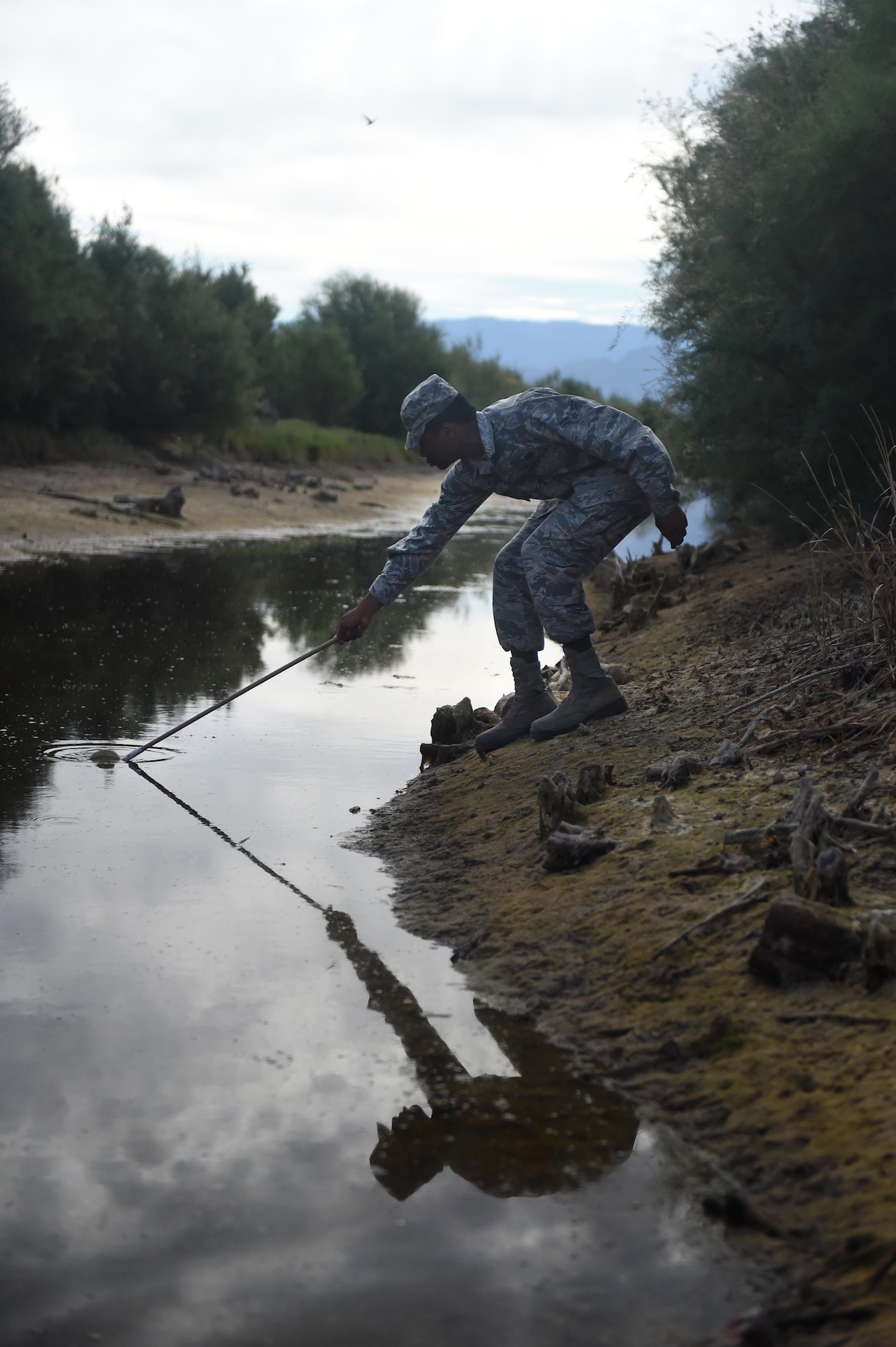 Airman 1st Class James, a 49th Civil Engineer Squadron pest management specialist, collects a water sample with mosquito larvae at Holloman Air Force Base, N.M., on July 7. Pest management personnel conduct pest management surveys, and determine actions needed to control infestations of plant and animal pests. (Last names are being withheld due to operational requirements. U.S. Air Force photo by Staff Sgt. Eboni Prince)